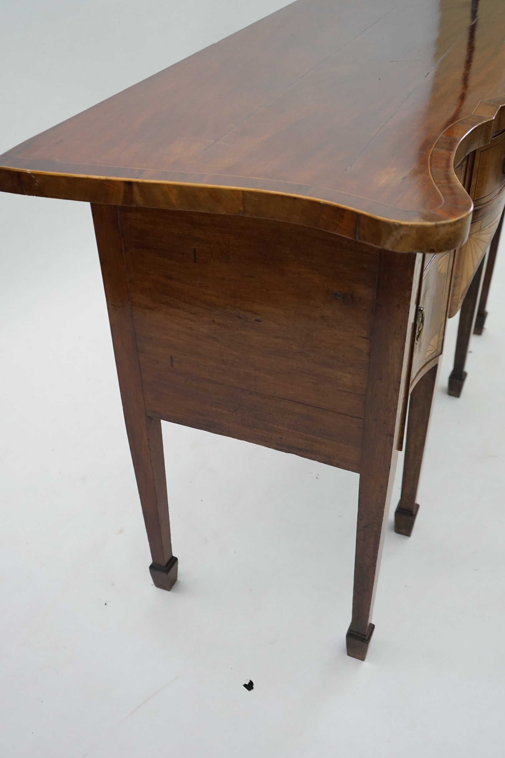 A George III inlaid mahogany serpentine sideboard